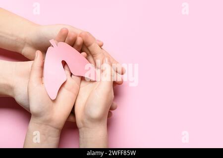 Hände von Frau und Kind mit Papierlunge auf rosa Hintergrund Stockfoto