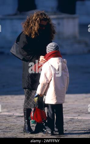 Frau, die sich um Schal auf Kind kümmert, Venedig, Italien Stockfoto