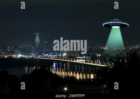 UFO. Außerirdische Raumschiffe strahlen Lichtstrahlen über der Nachtstadt aus Stockfoto