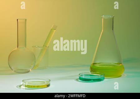 Laborkonzept mit gelber und blauer Flüssigkeit in einigen Glasgeräten. Wissenschaftslaborforschungskonzept Stockfoto