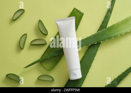 Weißer Behälter ohne Branding mit mehreren Aloe Vera Scheiben und Blättern verziert. Aloe Vera (Aloe barbadensis miller) hat Anti-Aging-Eigenschaften mit Vitam Stockfoto