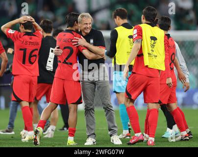 Doha, Katar. 30. Januar 2024. Südkoreas Cheftrainer Jurgen Klinsmann (C) umarmt sich mit Seol Young-Woo, nachdem er das Achtelfinale zwischen Saudi Arabien und Südkorea beim AFC Asiencup Qatar 2023 in Doha, Katar, 30. Januar 2024 gewonnen hatte. Quelle: Jia Haocheng/Xinhua/Alamy Live News Stockfoto