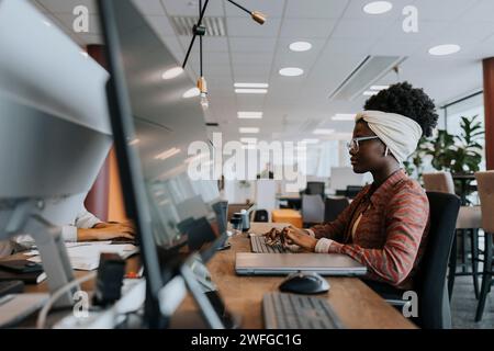 Seitenansicht einer selbstbewussten jungen Geschäftsfrau, die im Büro auf dem Schreibtisch schreibt Stockfoto