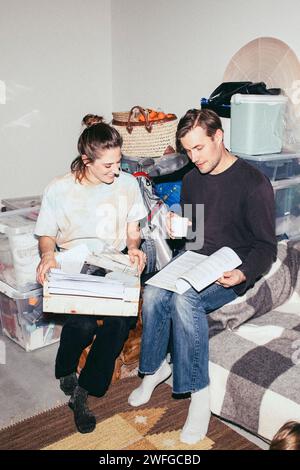 Ein Paar liest ein Buch, während er während des Umzugs sitzt Stockfoto