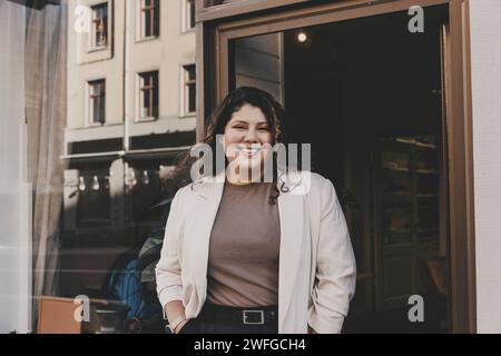 Portrait of smiling female business professional near office doorway Stockfoto