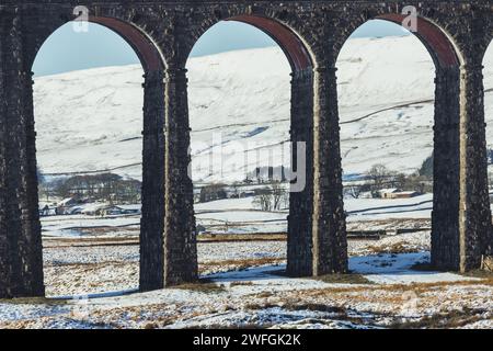 Der Ribblehead Viaduct im Winter in den Yorkshire Dales, mit viel Schnee auf dem Boden und dramatischer Bergkulisse. An einem sonnigen Tag aufgenommen. Stockfoto