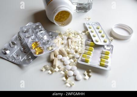 Viele verschiedene Vitamine und Tabletten in Packungen und ohne auf einem weißen Tisch Stockfoto