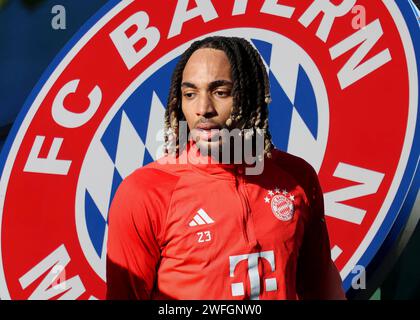 München, Deutschland 31. Januar 2024: Fussball, Herren, Saison 2023/2024, FC Bayern München ! Achtung Fotomontage! Hier im Bild Sacha Boey (FC Bayern München) Kopf, Oberkörper, im Hintergrund das Logo des Vereins, Symbolbild Stockfoto