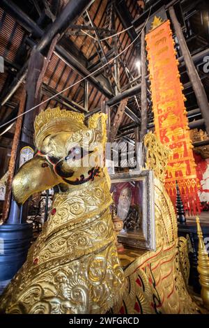 Ein Porträt des thailändischen Künstlers Thawan Duchanee auf einer goldenen Skulptur im Schwarzen Haus. Das „Baan Dam Museum“, auch bekannt als das „Schwarze Haus“ und oft auch als „Schwarzer Tempel“ bezeichnet, ist nicht wirklich ein Tempel, sondern eher ein Kunstmuseum und Atelier mit verschiedenen Kunstwerken. Das „Schwarze Haus“ ist auch die weltweit größte Sammlung von Tierresten, die zu Möbeln gemacht wurden. Es wurde von dem berühmten thailändischen Künstler Thawan Duchanee entworfen, der traditionelle nordthailändische Gebäude mit unkonventioneller und zeitgenössischer Architektur kombiniert. Stockfoto