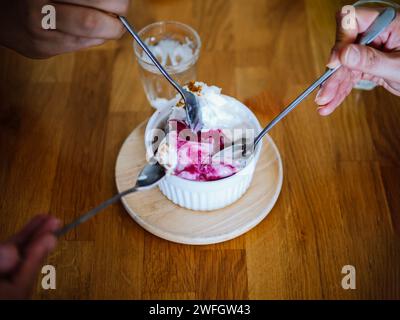 Sommerdessert mit Eis, Heidelbeeren, Himbeeren und Heidelbeeren. Blick aus einem hohen Winkel auf Joghurt und Heidelbeereis in der Schüssel auf dem Tisch. Stockfoto