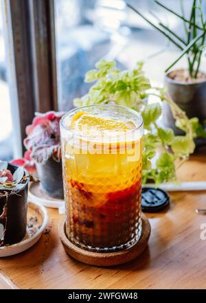 Ein Glas Hummelcocktail mit Eis. Doppelter Espresso mit Orangensaft und Karamellsirup mit Orangensaft und Orangenscheiben auf dem Glas. Frisch und Stockfoto