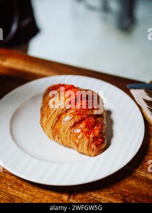 Croissant, französisches Croissant oder französisches Brot oder Pudding Croissant mit Puderzucker zum Servieren. Frisches französisches Croissant auf weißer Keramikplatte Stockfoto