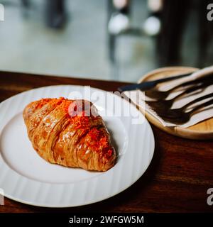 Croissant, französisches Croissant oder französisches Brot oder Pudding Croissant mit Puderzucker zum Servieren. Frisches französisches Croissant auf weißer Keramikplatte Stockfoto