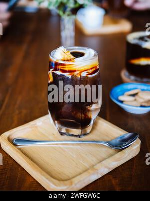 Eis Americano Coconut. Ein klares Glas Eiscreme mit frischem Kokoswasser und Kokosnussfleisch auf dem Tisch, ein kaltes Sommergetränk und ein Haus B Stockfoto