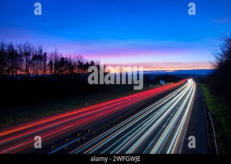 Sonnenaufgang über der Autobahn M40 mit Lichtspuren. Banbury, Oxfordshire, England Stockfoto