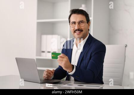 Selbstbewusster kaukasischer Erwachsener Geschäftsmann in Anzug am Tisch mit Computer Stockfoto