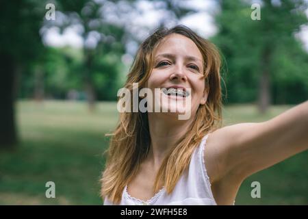 Eine glückliche junge Frau mit Zahnspangen, die die Natur genießt Stockfoto