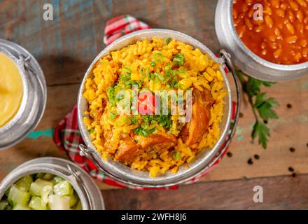 Typisch brasilianisches Gericht ( Galinhada ) mit Curcuma gewürzt, Huhn und Reis auf rustikalem Set, Blick von oben Stockfoto