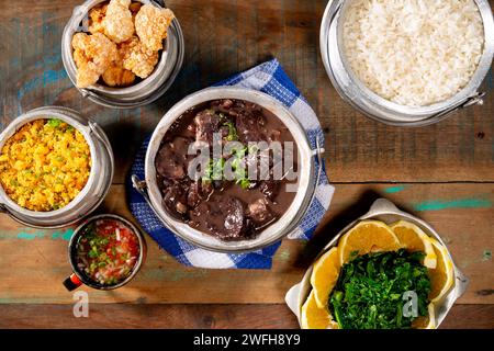 Typisch brasilianisches Gericht Feijoada auf Basis von schwarzen Bohnen und Schweinefleisch mit Crakloing, Reis und Orange Stockfoto