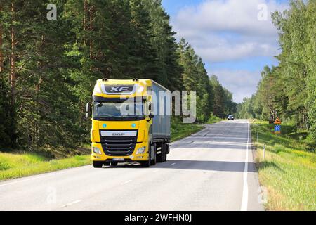 Der gelbe DAF XF Lkw-Auflieger liefert an einem sonnigen Sommermorgen Güter auf der Autobahn. Salo, Finnland. Juli 2023. Stockfoto