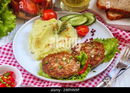 Schnitzel mit Kartoffelpüree auf einem Teller auf einer karierten Tischdecke Stockfoto
