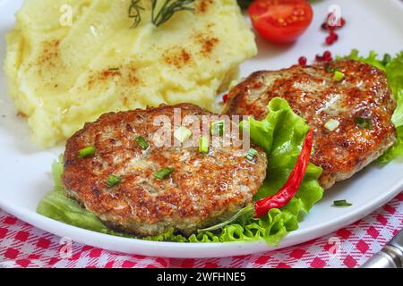 Schnitzel mit Kartoffelpüree auf einem Teller auf einer karierten Tischdecke Stockfoto