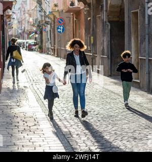 Zwei Frauen und zwei Kinder laufen auf einer Straße in Carloforte, San Pietro Island, Süd-Sardina, Italien Stockfoto