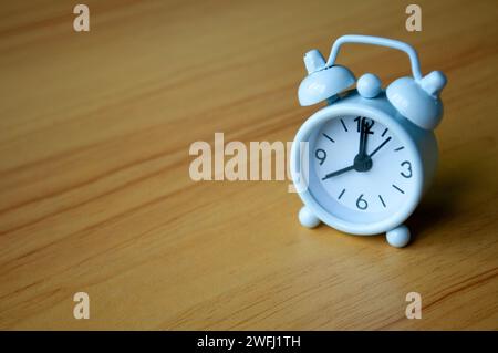 Wecker am Tisch, der auf 8:00 Uhr zeigt, mit Platz für Text. Zeitkonzept und Kopierraum. Stockfoto