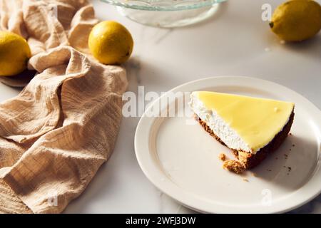 Mascarpone-Käsekuchen mit Zitronenquark und Shortbread-Basis. Weißer Marmorhintergrund. Erstklassiges Lebensmittelfoto Stockfoto