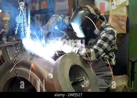 Schweißer in Schutzkleidung am Arbeitsplatz in einer Industrie Unternehmen im Stahlbau Stockfoto