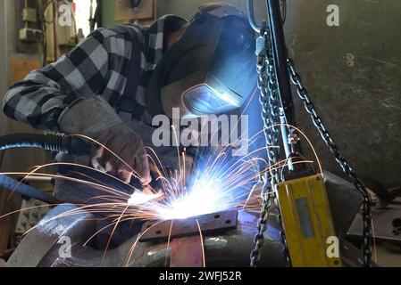 Schweißer in Schutzkleidung am Arbeitsplatz in einer Industrie Unternehmen im Stahlbau Stockfoto