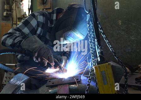 Schweißer in Schutzkleidung am Arbeitsplatz in einer Industrie Unternehmen im Stahlbau Stockfoto