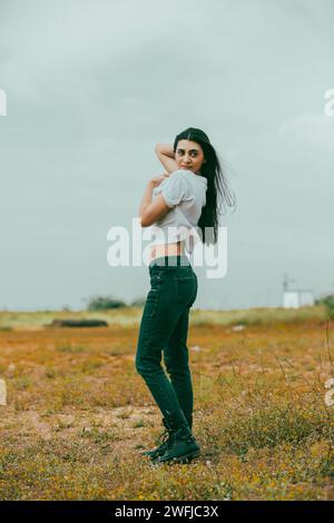 Schöne junge Frau, die auf dem Feld steht Stockfoto