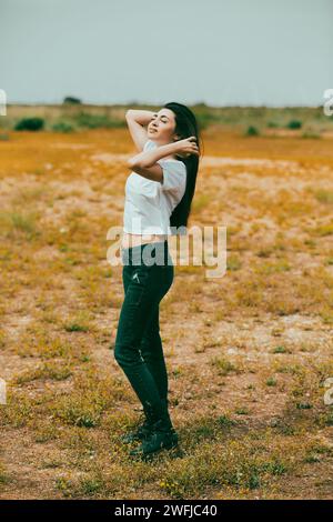 Schöne junge Frau, die auf dem Feld steht Stockfoto