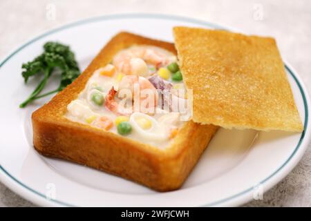 Sargbrot, taiwanesische Küche. Es ist Weißbrot, das in Öl frittiert wurde, mit ausgehöhlter Mitte und gefüllt mit Meeresfrüchtesuppe. Stockfoto