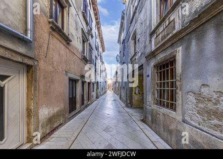 Bild einer typischen Straßenszene aus der historischen kroatischen Stadt Voznjan mit Kopfsteinpflasterstraßen und alten Gebäuden im Morgenlicht Stockfoto
