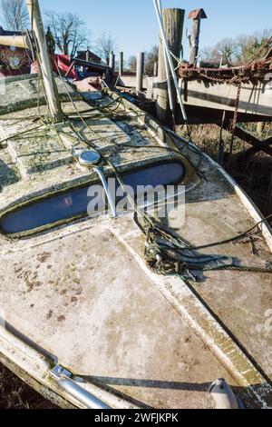 Nahaufnahme eines alten Segelbootes, das eine gute Reinigung und Reparatur braucht, die an Land vertäut ist Stockfoto