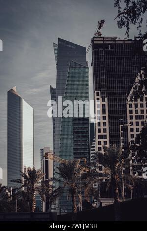 Die Wolkenkratzer in einer modernen Stadt vor einem sonnendurchfluteten Hintergrund: Arabischer Golf, Kuwait Stockfoto