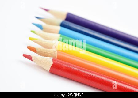 Nahtlose Holzstifte in Regenbogenfarben mit selektivem Fokus auf einen roten Bleistift. Fotografiert auf weißem Hintergrund. Nahaufnahme. Stockfoto