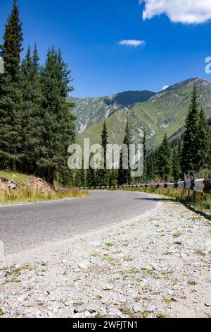 Straße im Bergwald, blauer Himmel am Sommertag Stockfoto