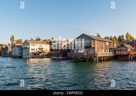 Historische Holzgebäude auf Pfählen ragen in der Penn Cove in Coupeville, Whidbey Island, Washington, ins Wasser. Stockfoto