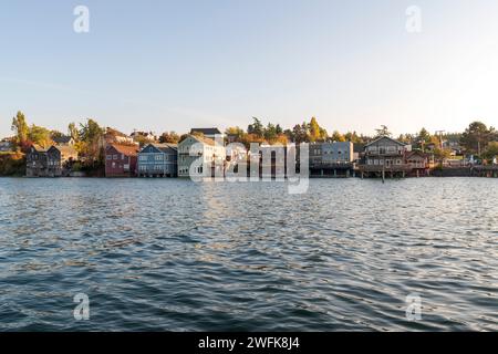 Historische Holzgebäude auf Pfählen ragen in der Penn Cove in Coupeville, Whidbey Island, Washington, ins Wasser. Stockfoto