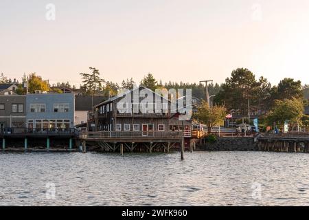 Historische Holzgebäude auf Pfählen ragen in der Penn Cove in Coupeville, Whidbey Island, Washington, ins Wasser. Stockfoto