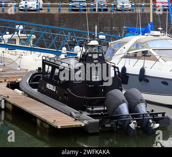 Schwarzes Schnellboot markiert in walisisch - Heddlu - (Polizei), das in Penarth Marina vor Anker liegt. Vom Januar 2024. Winter Stockfoto