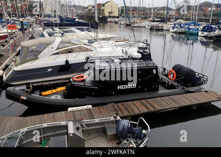 Schwarzes Schnellboot markiert in walisisch - Heddlu - (Polizei), das in Penarth Marina vor Anker liegt. Vom Januar 2024. Winter Stockfoto