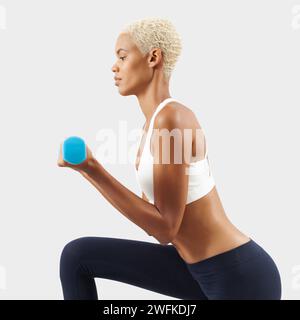 Lateinamerikanische Frau hebt Kurzhanteln, junge weibliche Athletin macht Fitnesstraining, engagiert sich in körperlicher Aktivität, um Gesundheit und Fitness zu verbessern. Sportswo Stockfoto