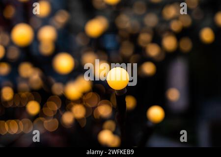 Ein gelbes Licht im Fokus und viele verschwommene in einem Bokeh-Hintergrund können als horizontale Ausrichtung des Texturhintergrunds verwendet werden. Stockfoto