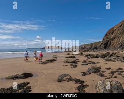 Urlauber, die einen Platz am wunderschönen Sandstrand von Marloes Sands in Pembrokeshire in Wales finden Stockfoto