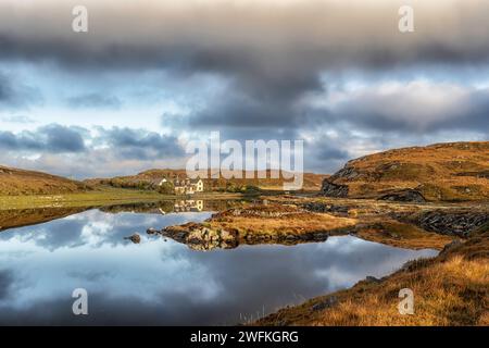 Das Doune Braes Hotel in der Township Carloway spiegelt sich in den ruhigen und stillen Gewässern von Loch an Dunain auf der Isle of Lewis in den Äußeren Hebriden wider. Stockfoto