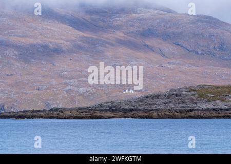 Magische Aussicht vom Strand Luskentyre auf ein einsames Haus in den Bergen um Cliasmol. Stockfoto